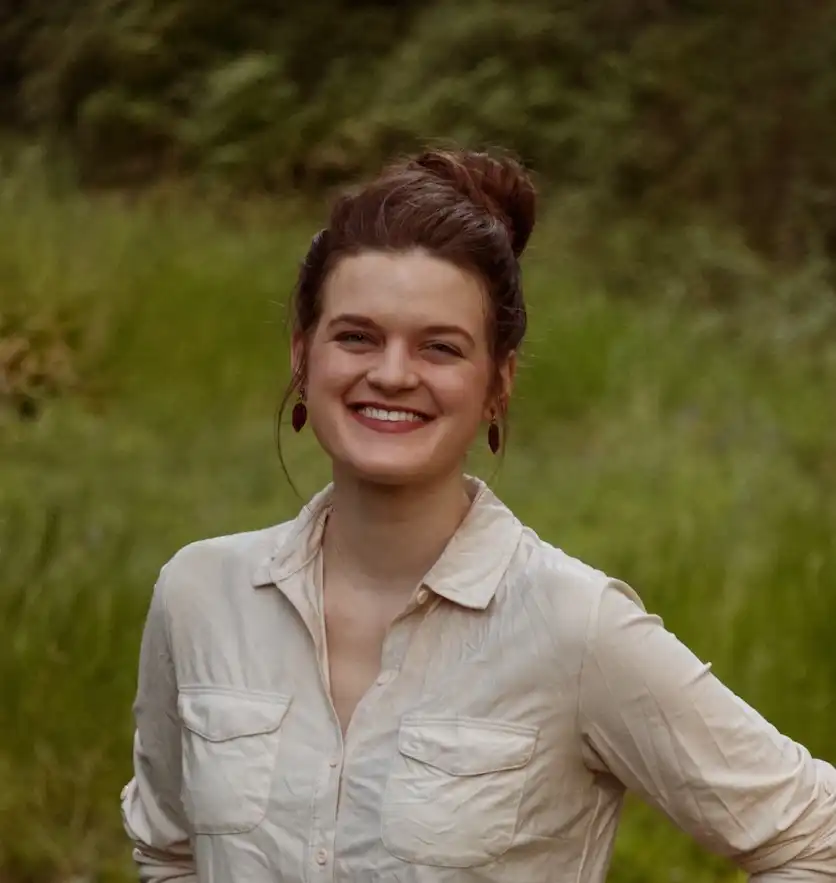 Grace, the artist behind Pepper's Post, standing in a meadow